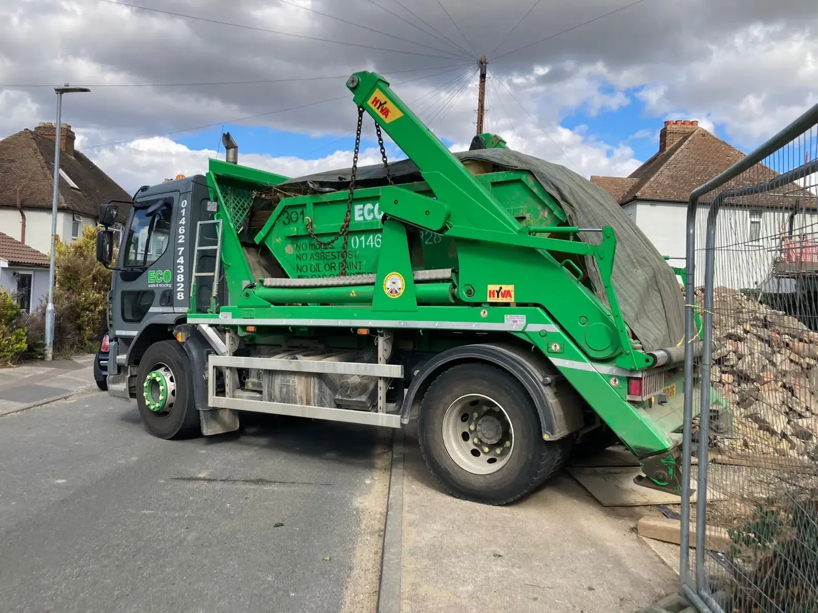 skip truck near rubble at site